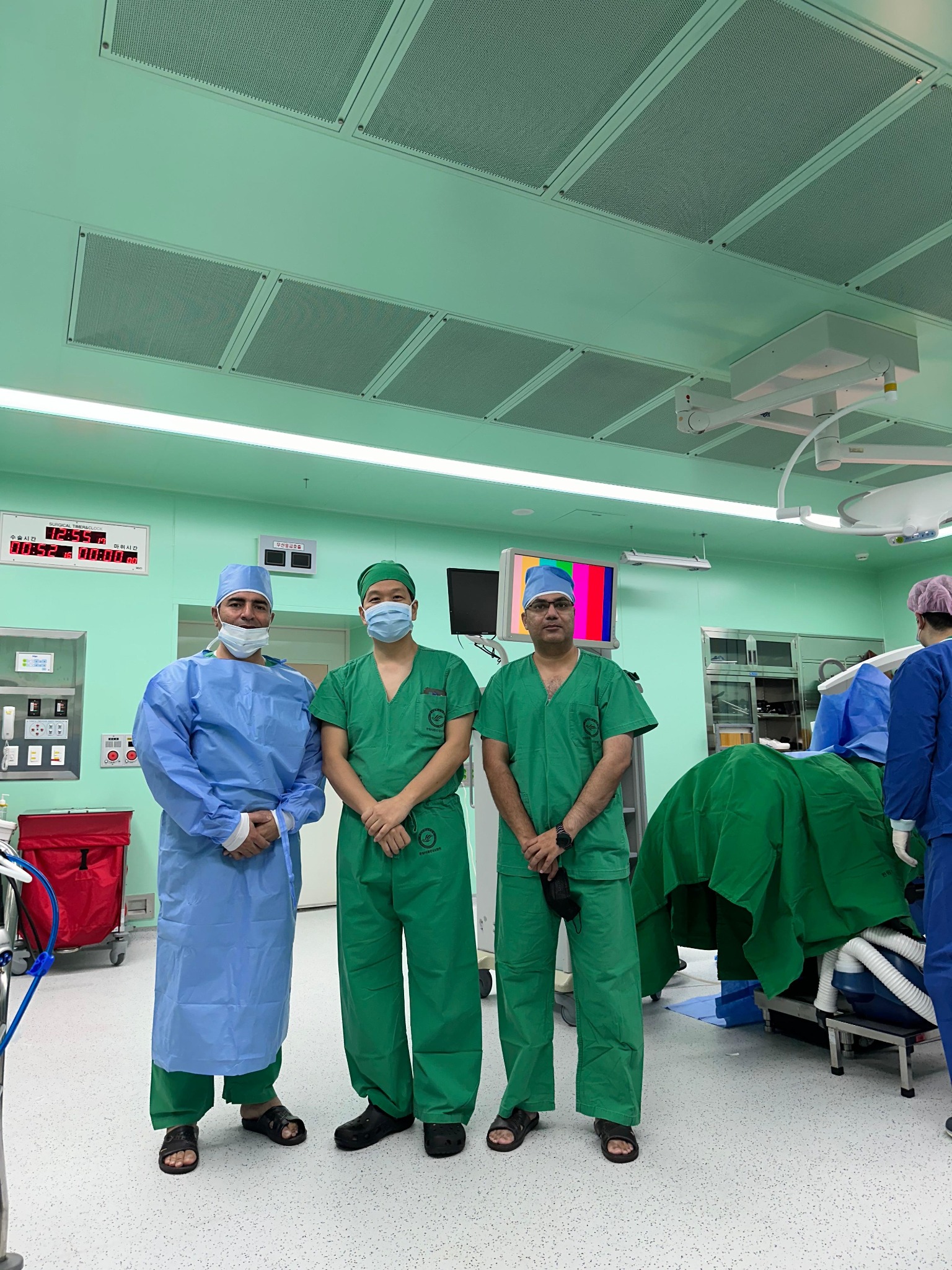 Dr. Mian Awais operating room surgical team in green scrubs